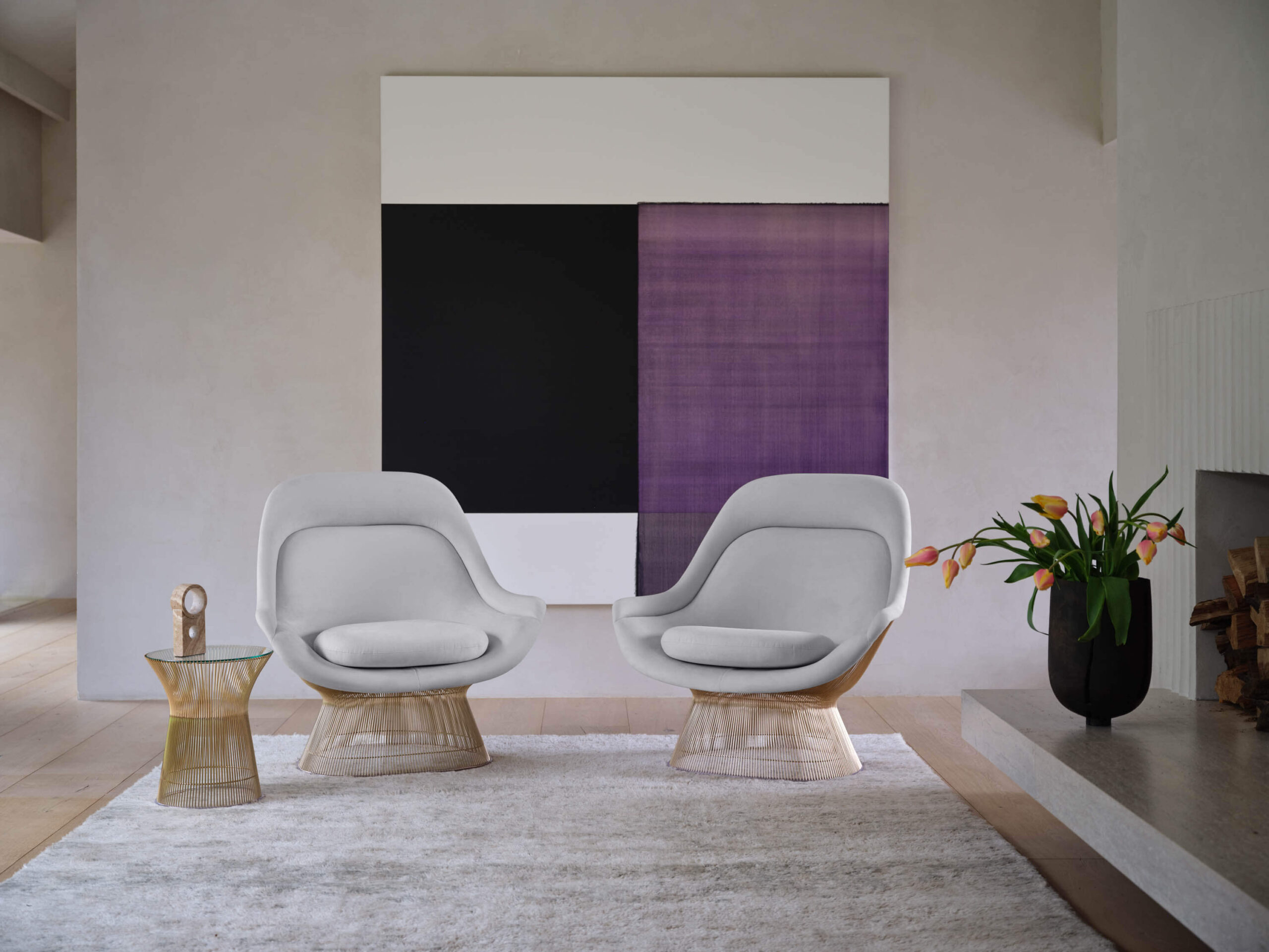 two Platner Easy Lounge Chair and a painting behind