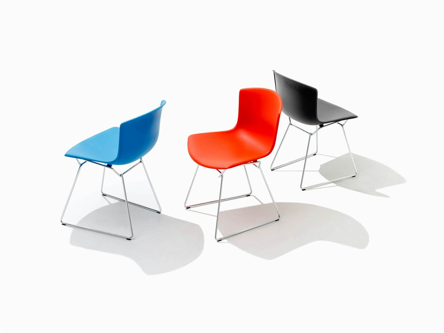 three bertoia molded shell side chairs in different colours