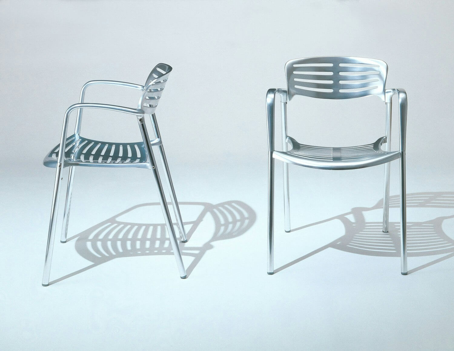 two toledo aluminium stacking chairs front and side in a white background