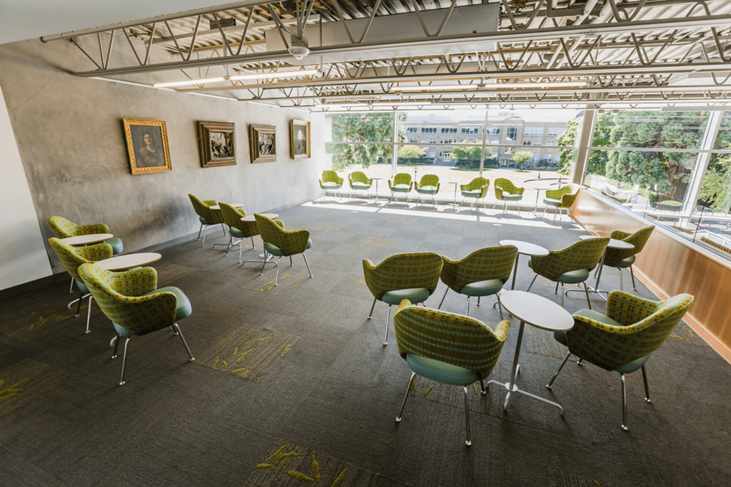 elegant room at a university campus featuring lounge chairs and paintings