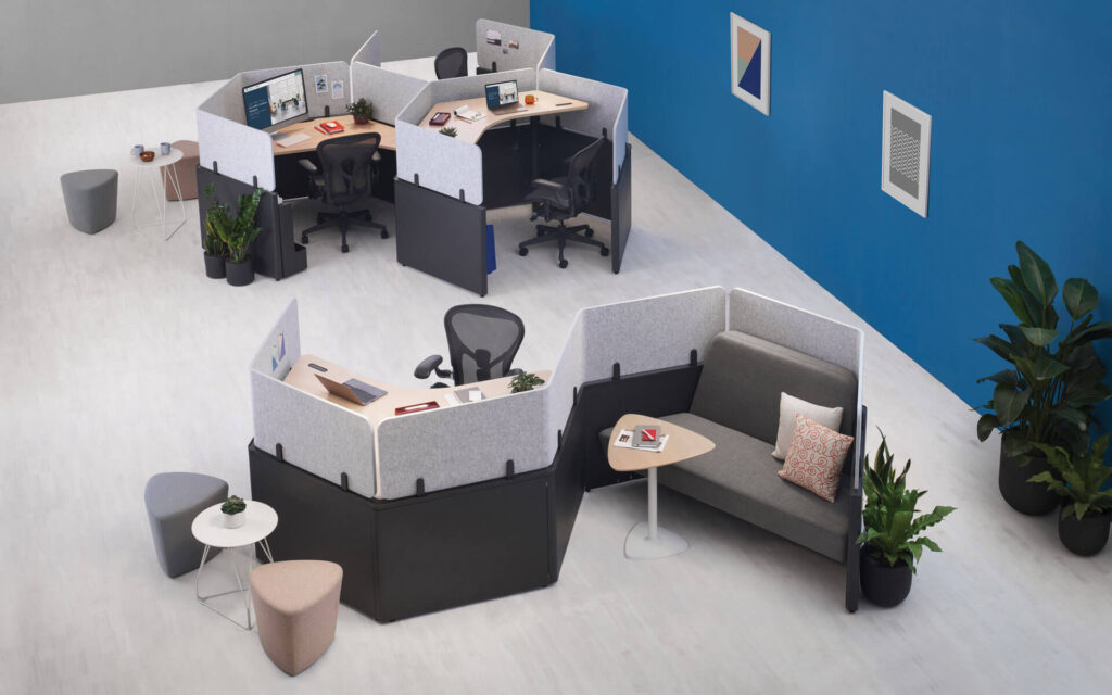 workstation cubicles at a public service office featuring sofas and ergonomic black chairs looking from above